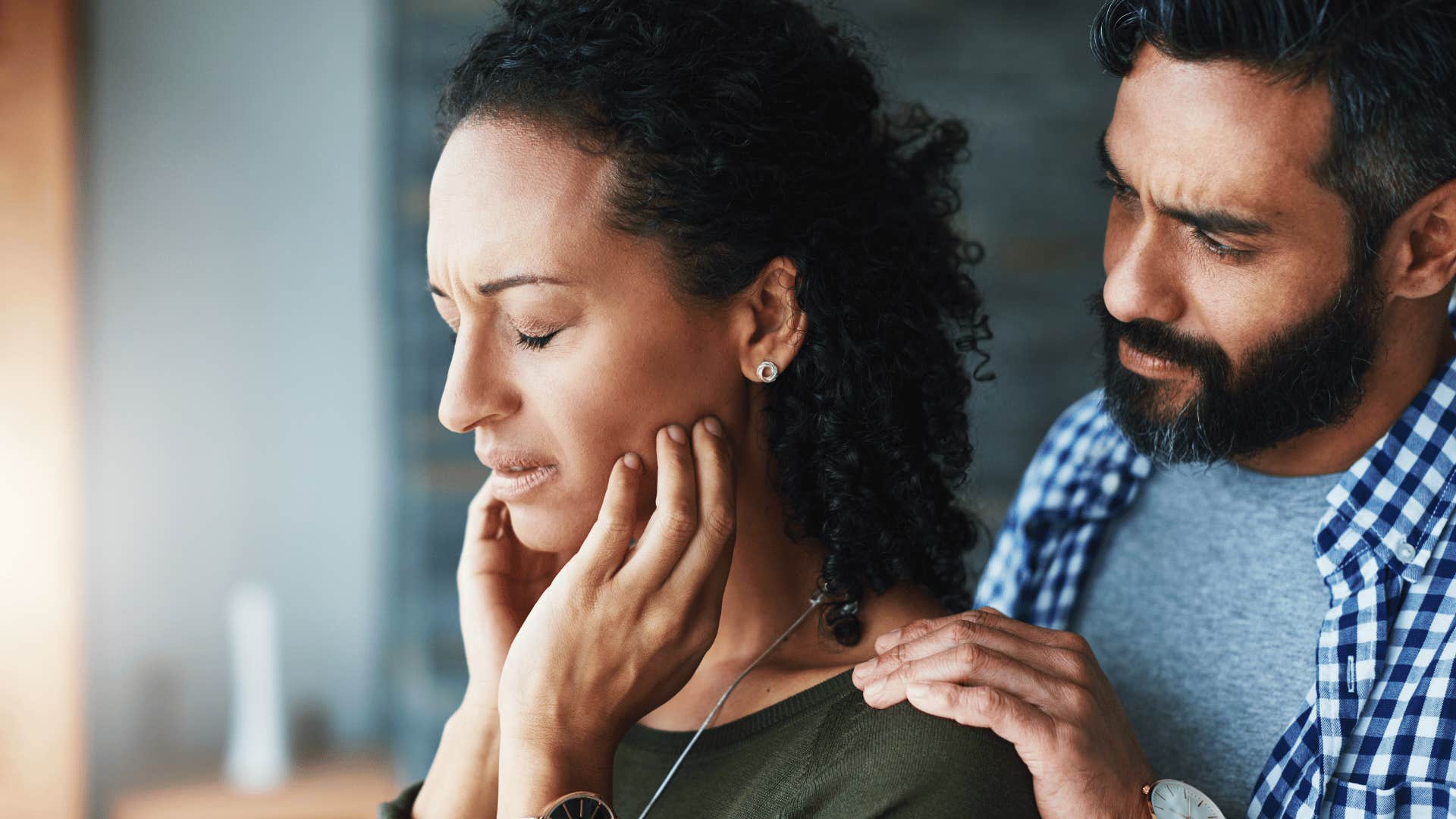 woman upset while man comforts her 