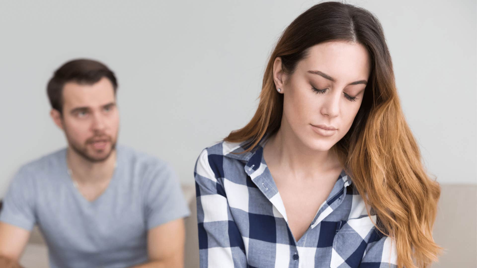 woman looking sad while partner looks at her