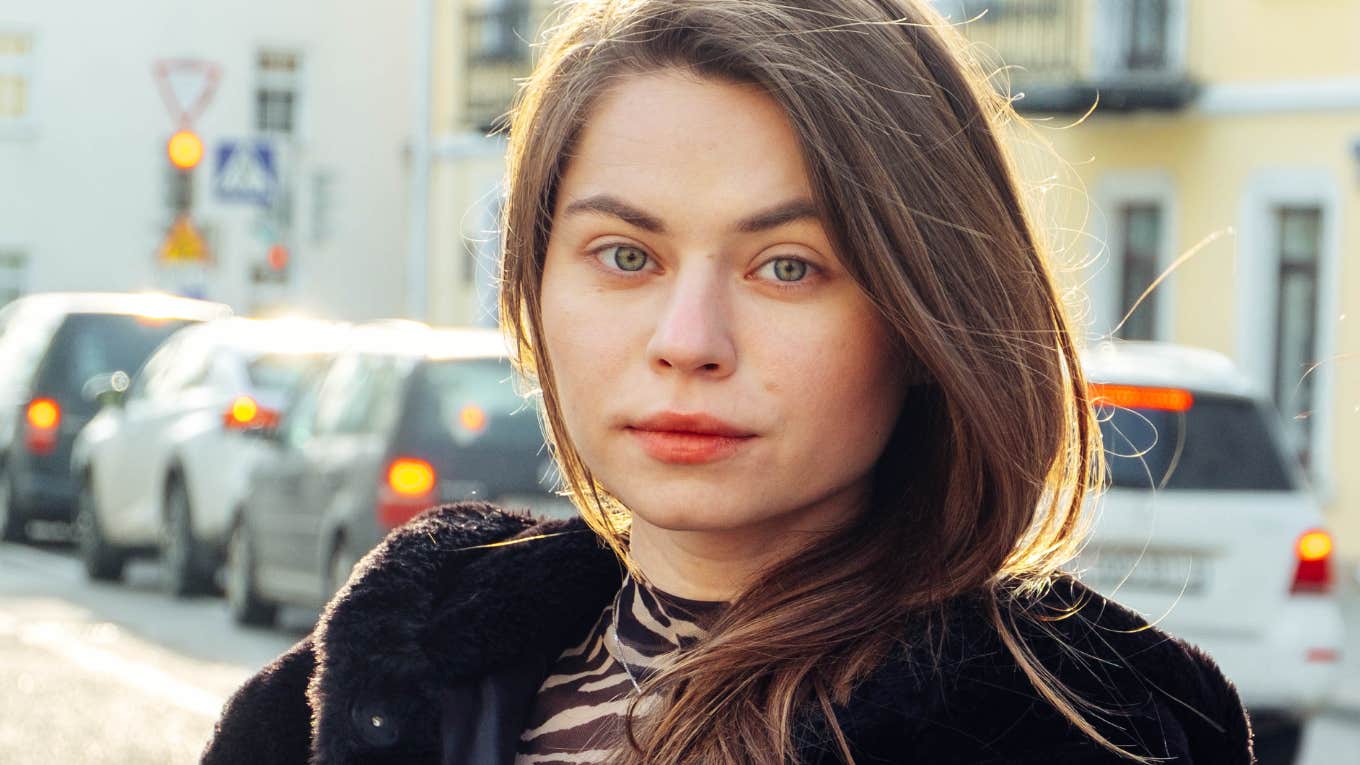 woman walks the streets full of cars in a black fur coat