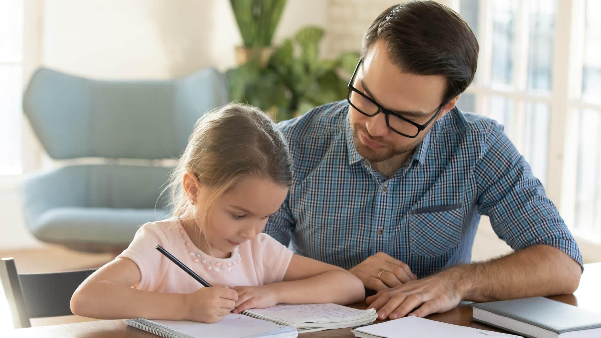 Dad helping his young daughter with her homework.