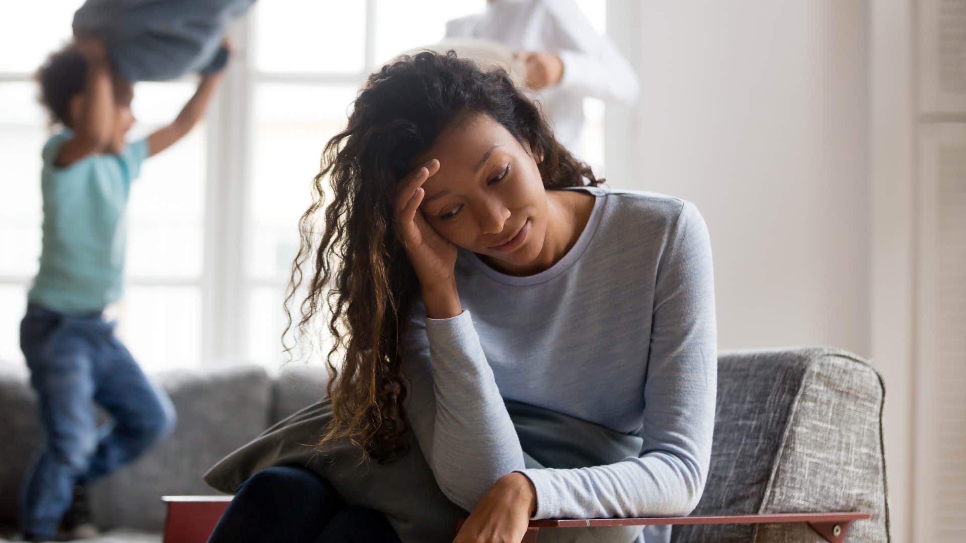 Young mom looking stressed in her living room.