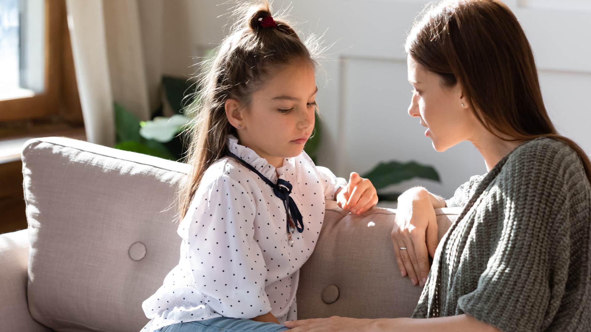 Woman talking to her upset teenage daughter.