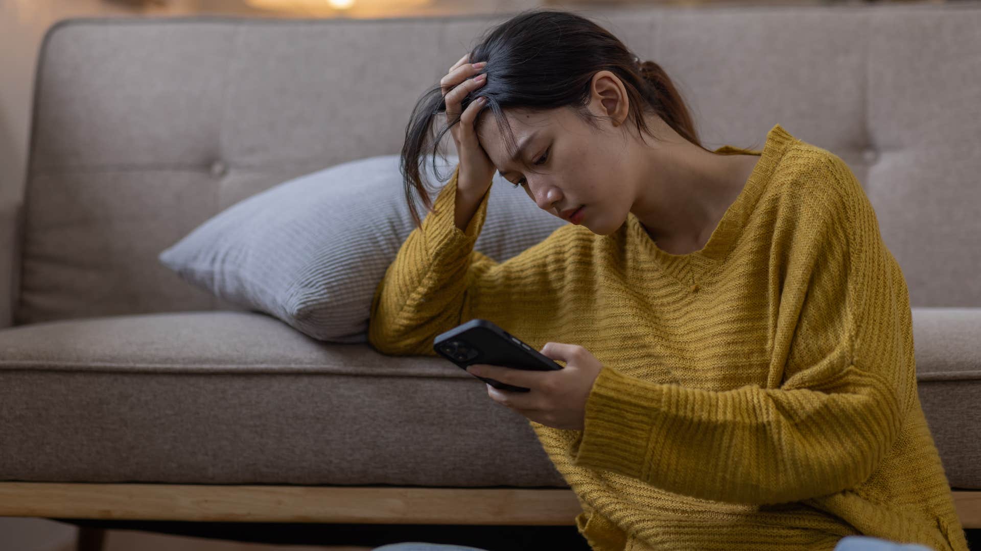 Anxious woman looking upset staring at her cell phone.