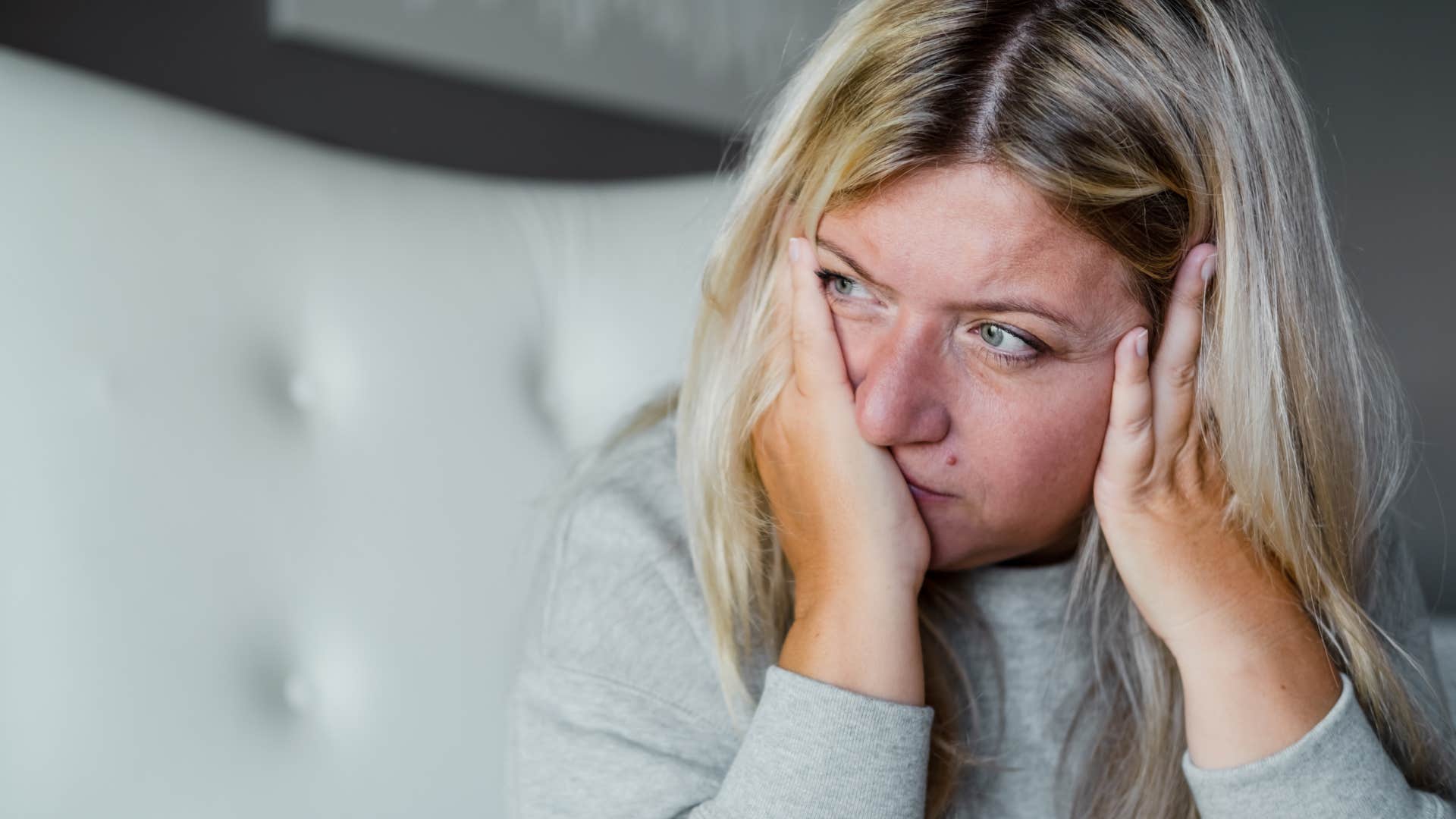 Insecure and sad woman holding her face in her hands.