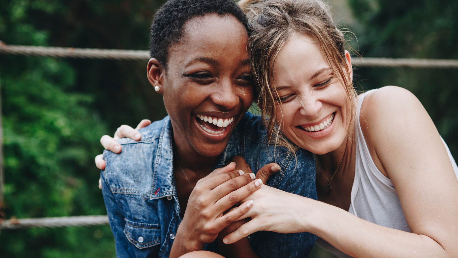 Two friends smiling and hugging each other.