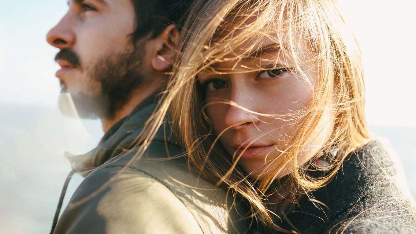 blonde haired woman rests her head on a man with a brown beard