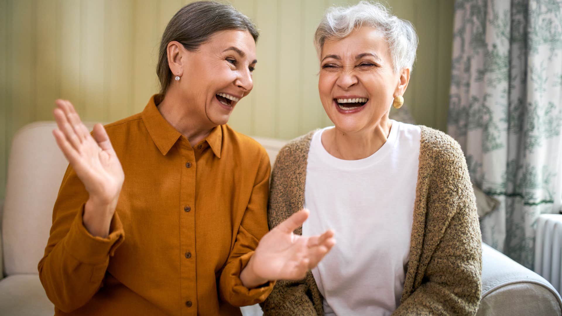 Two older women smiling and laughing together.