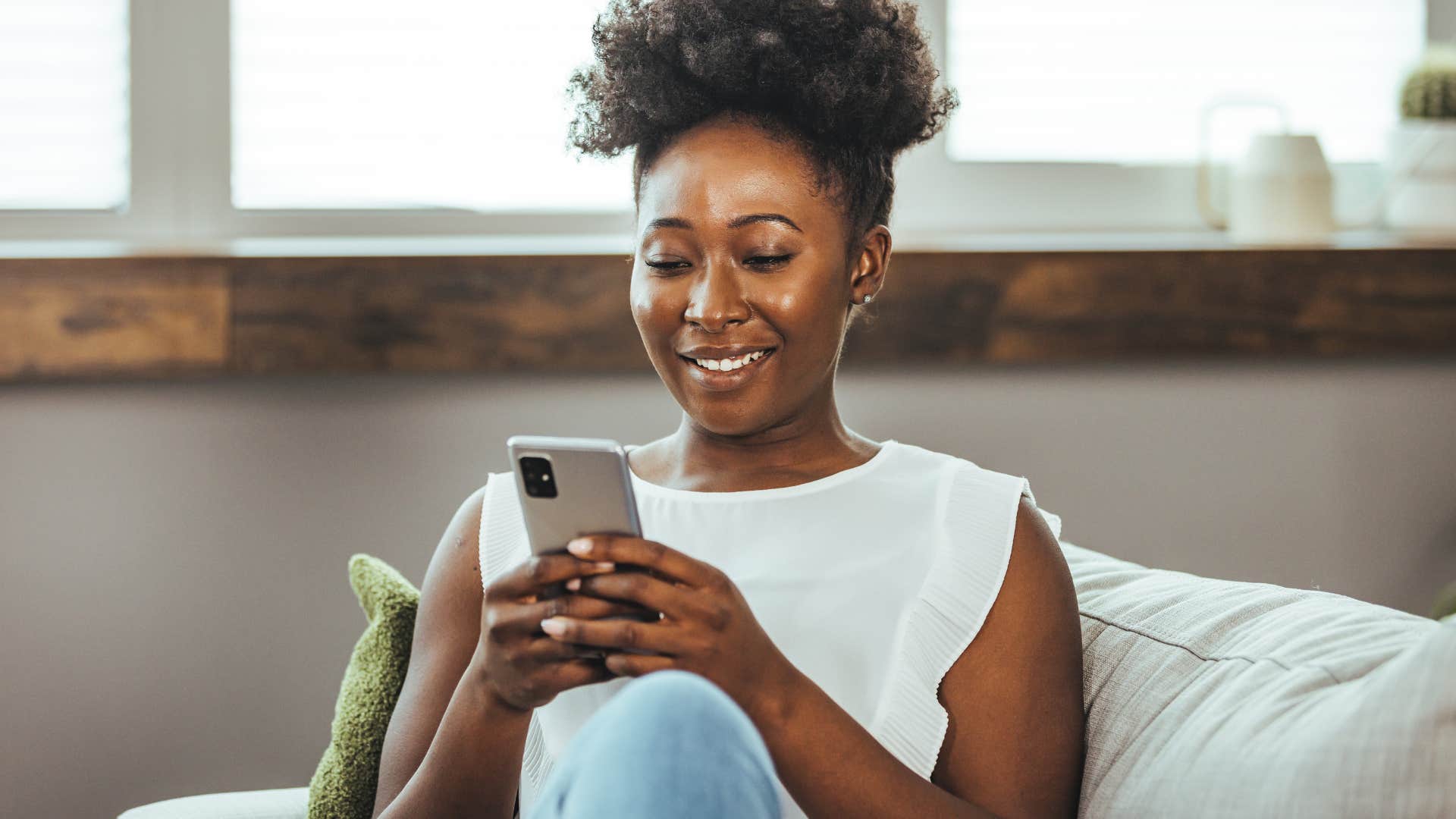 Woman smiling and holding her cell phone.