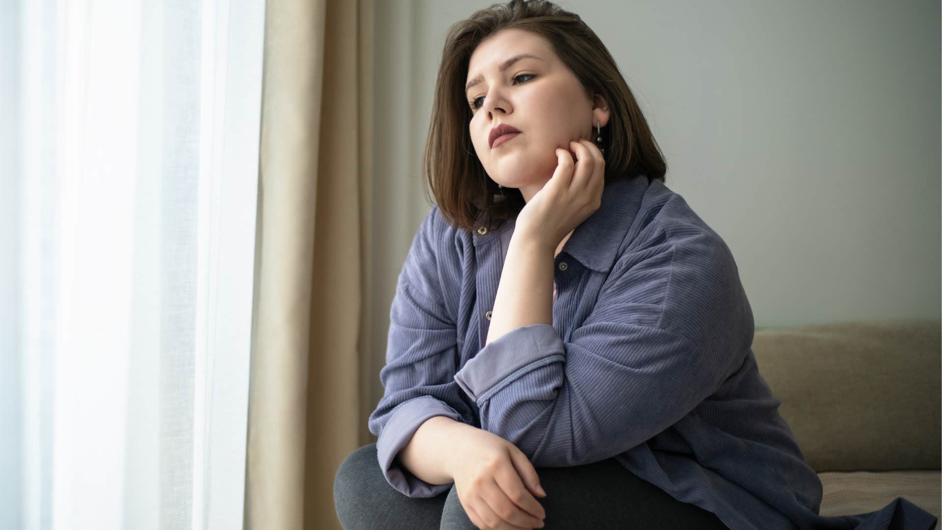 Sad woman looking out the window.