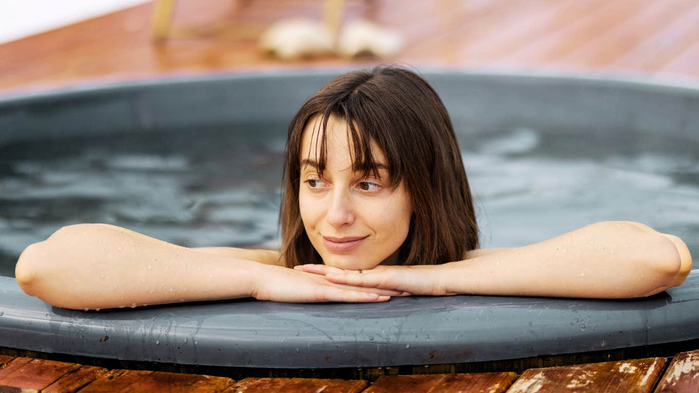 Female soaking in a hot tub to calm her racing mind.