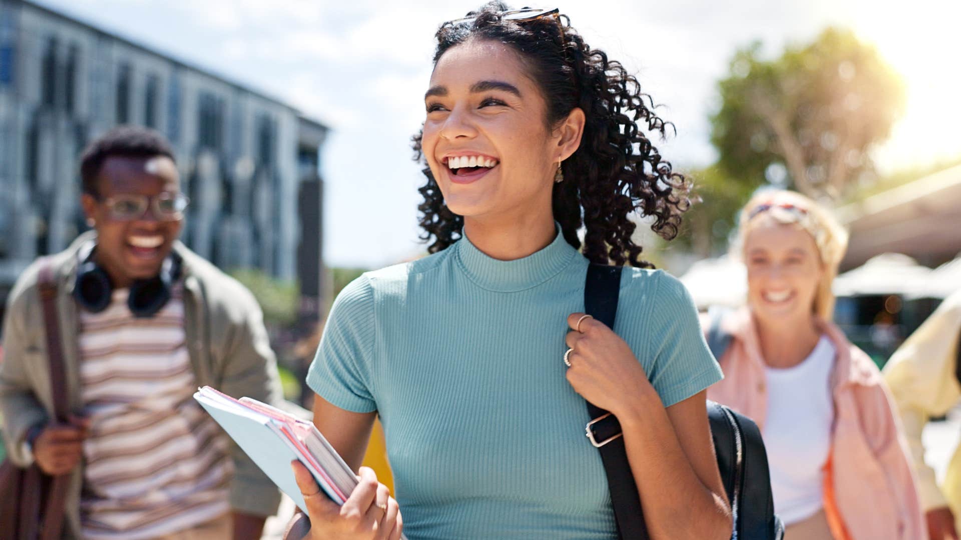 Young woman smiling and walking outside.