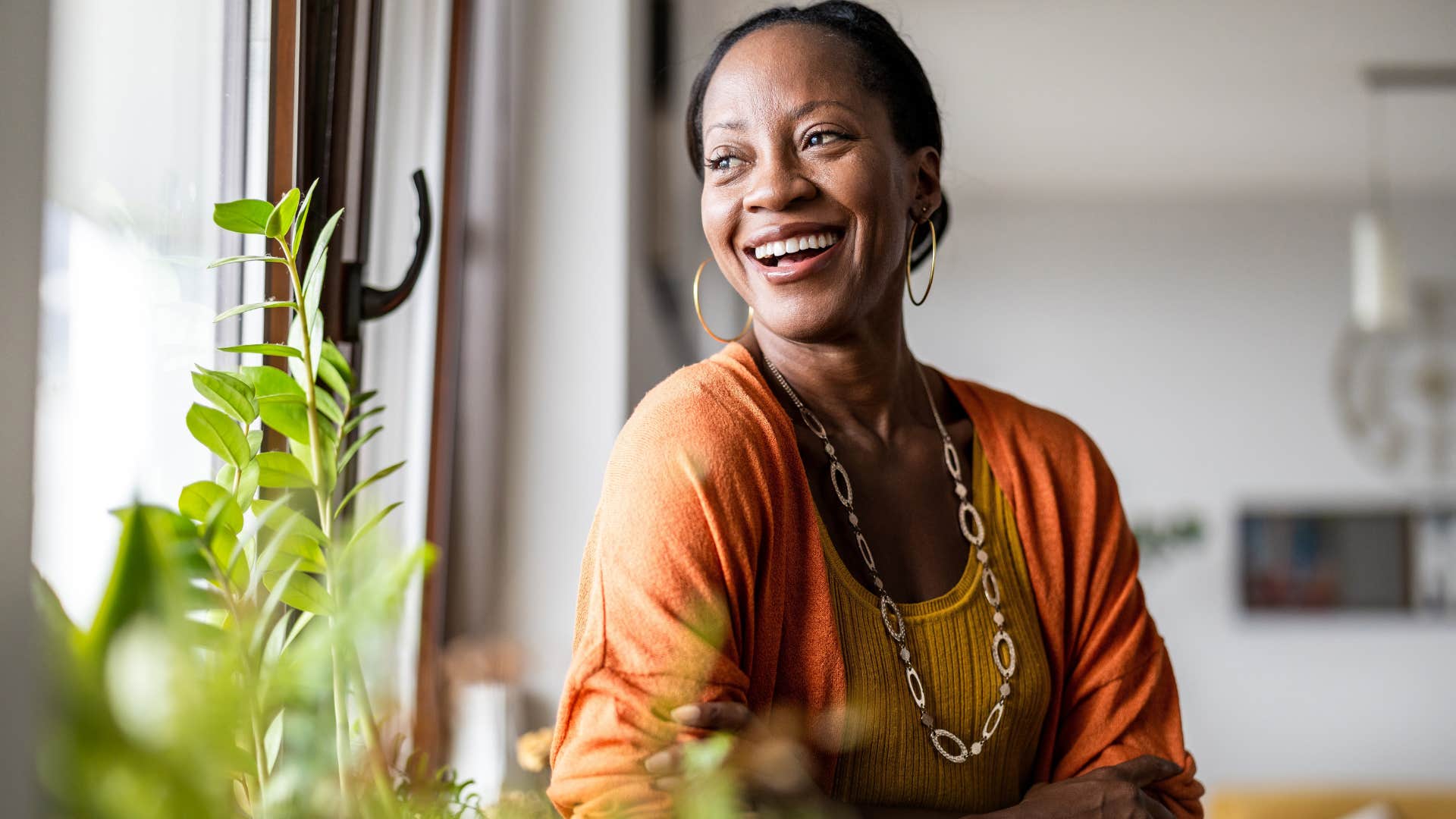 Woman smiling and looking out her window.