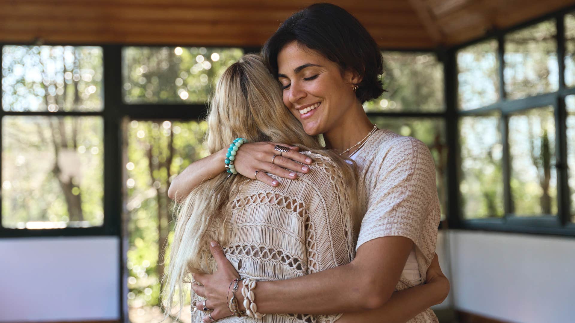 Woman smiling and hugging another woman.