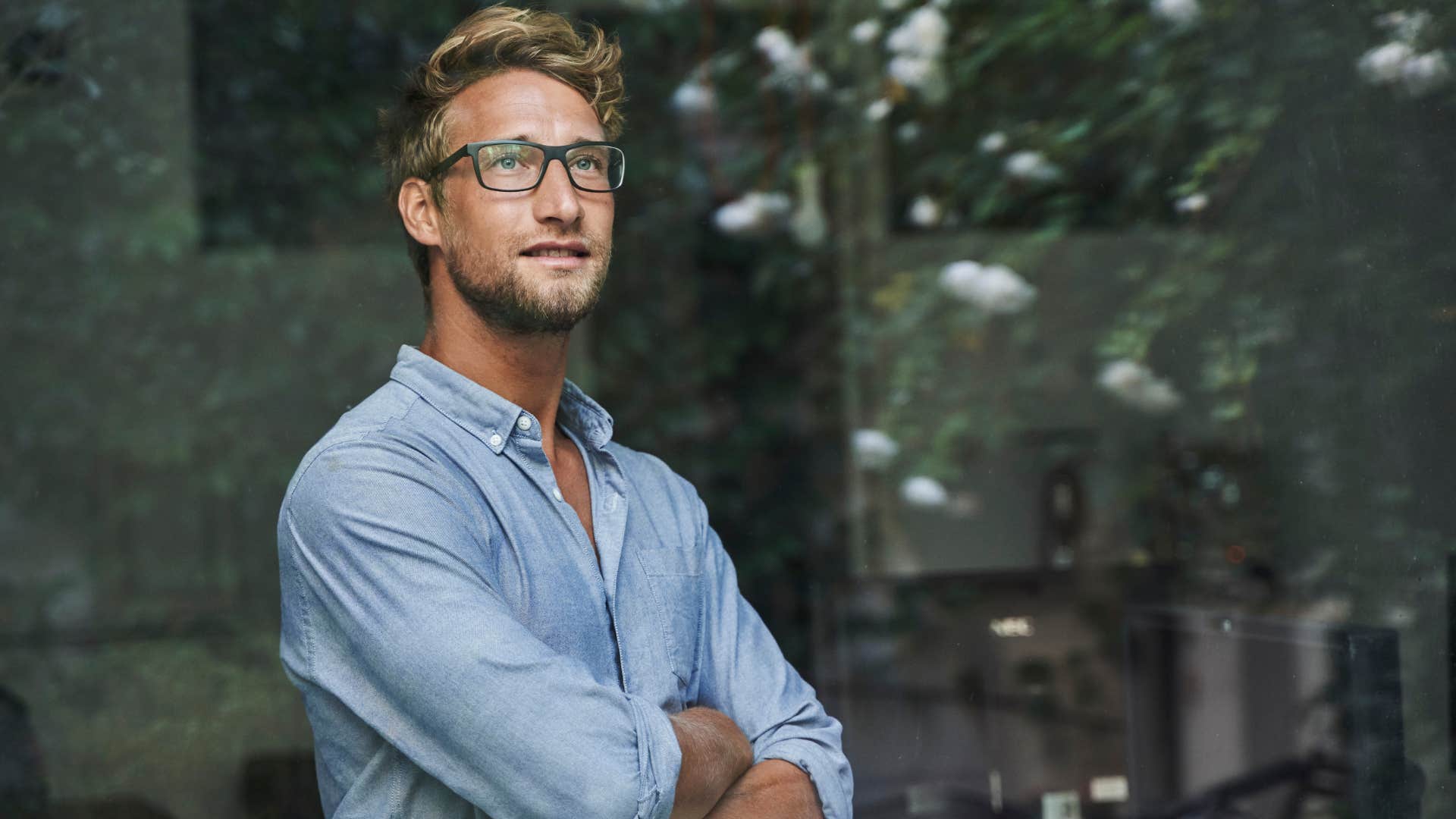 Young man smiling and looking out a window.