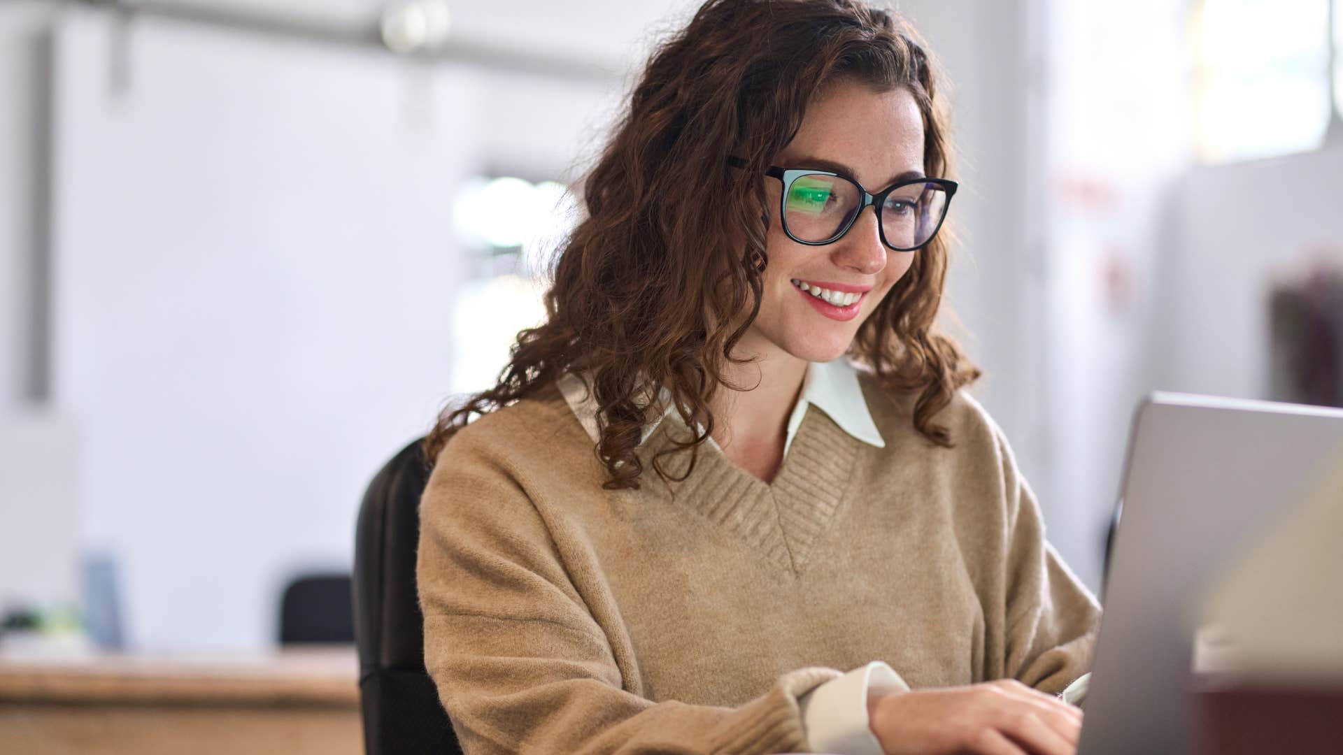 Woman smiling at her work desk.