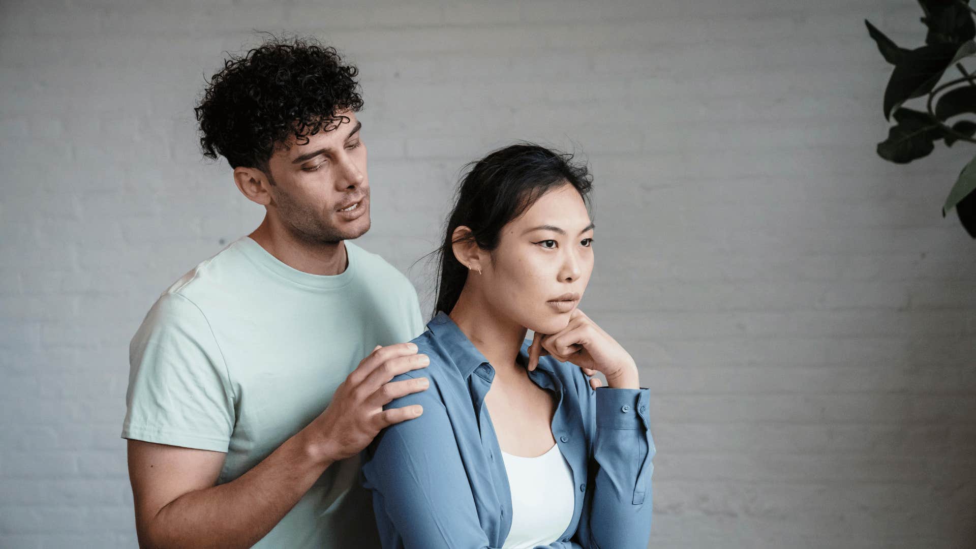 man holding the shoulders of a woman facing away from him