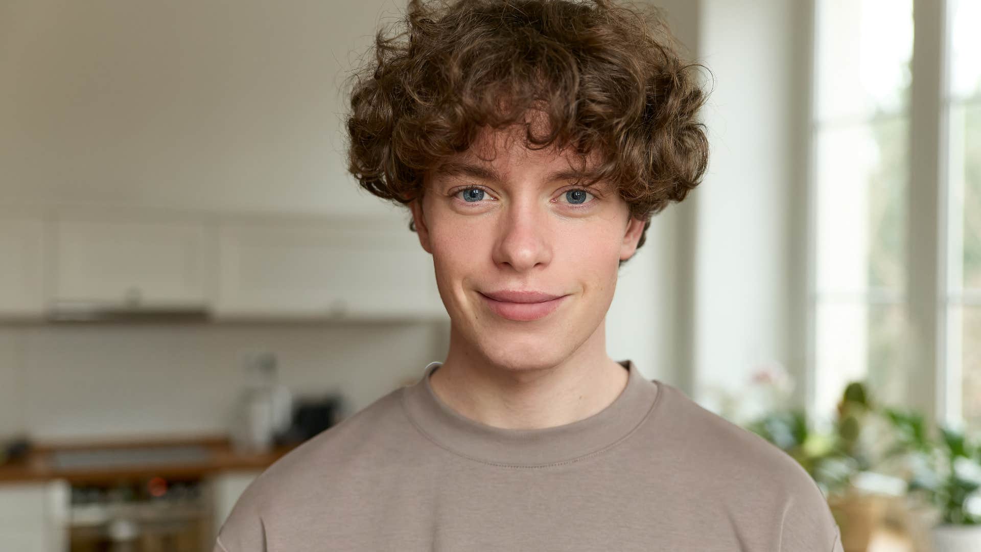 Teenage boy smiling at the camera at home.