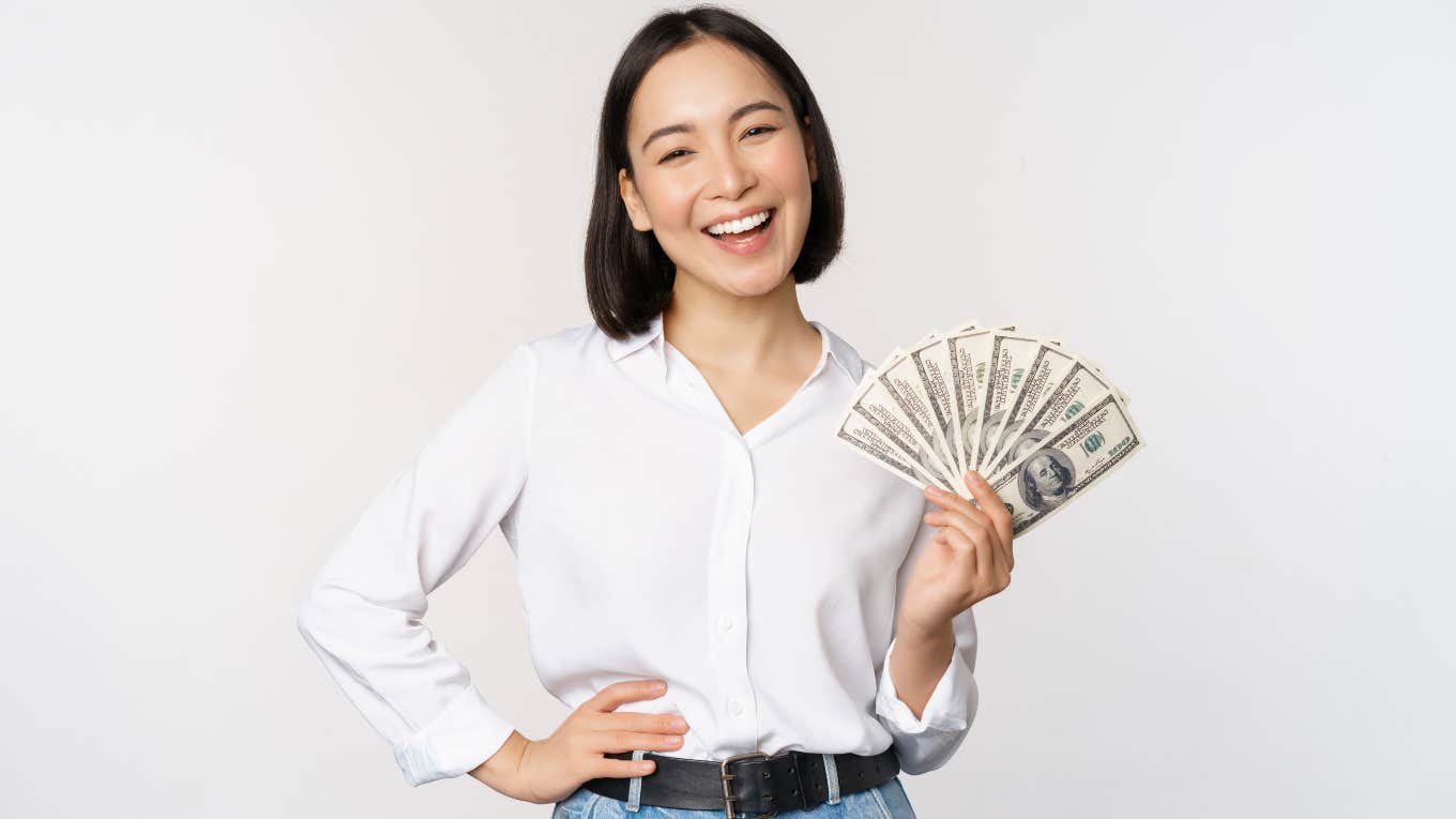 happy, smiling woman holding cash