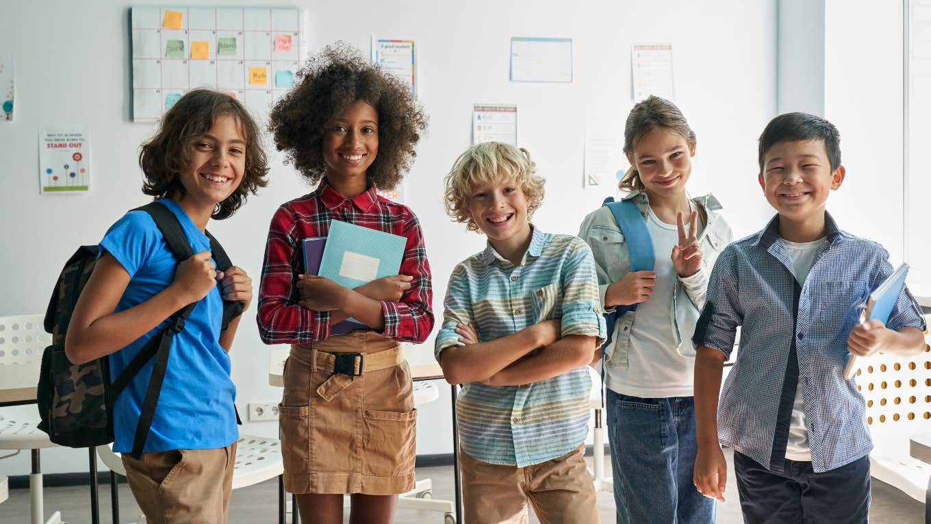 group of middle schoolers standing in front of a white board