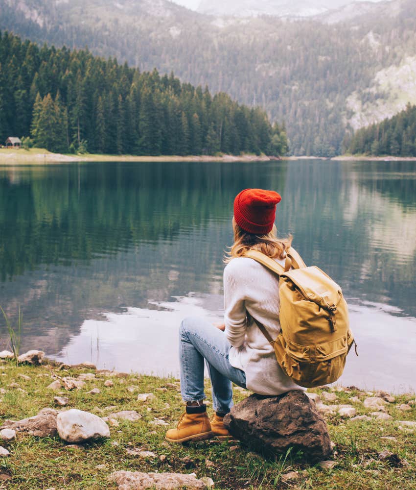 woman enjoying the view sitting by a lake