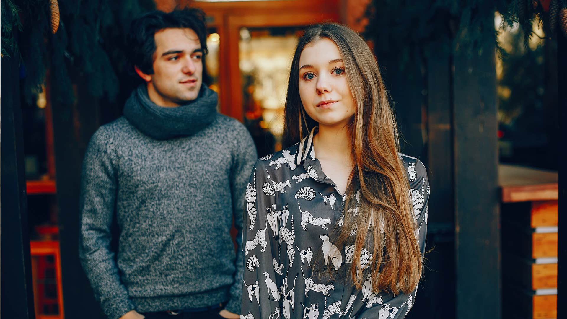 Young couple in a winter city. Man in a gray sweater. Lady with long hair