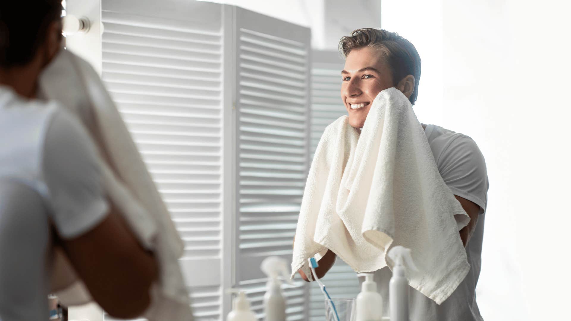 Man dries face after showering and shaving