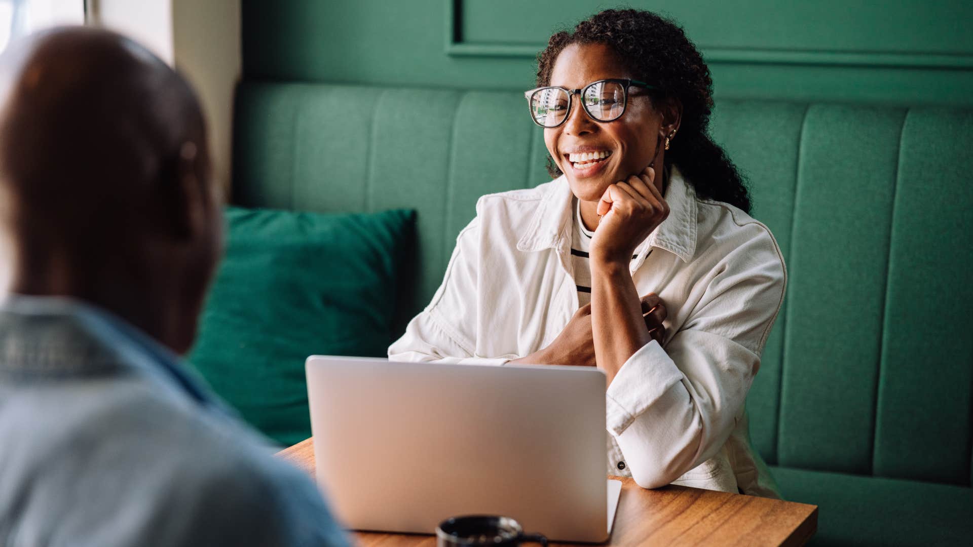 Woman smiling and staring at a man across the table. 