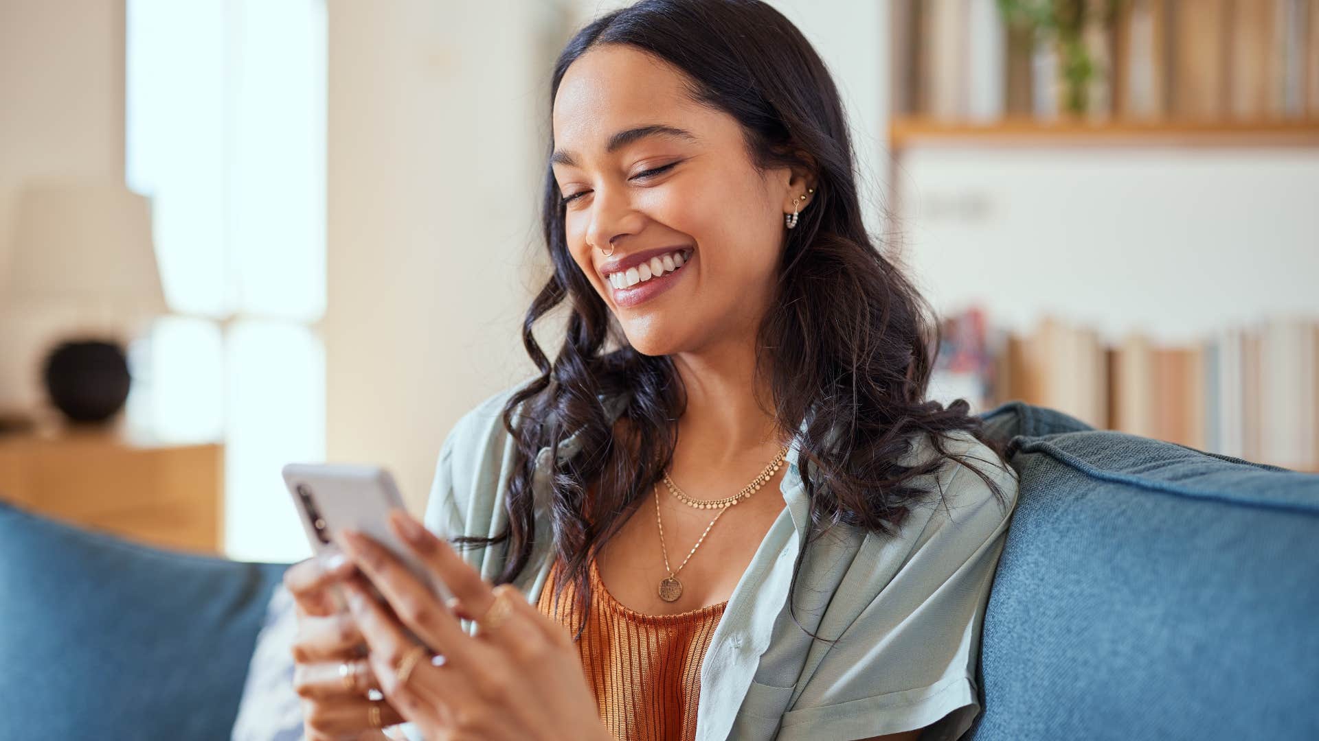 Woman smiling at her cell phone. 