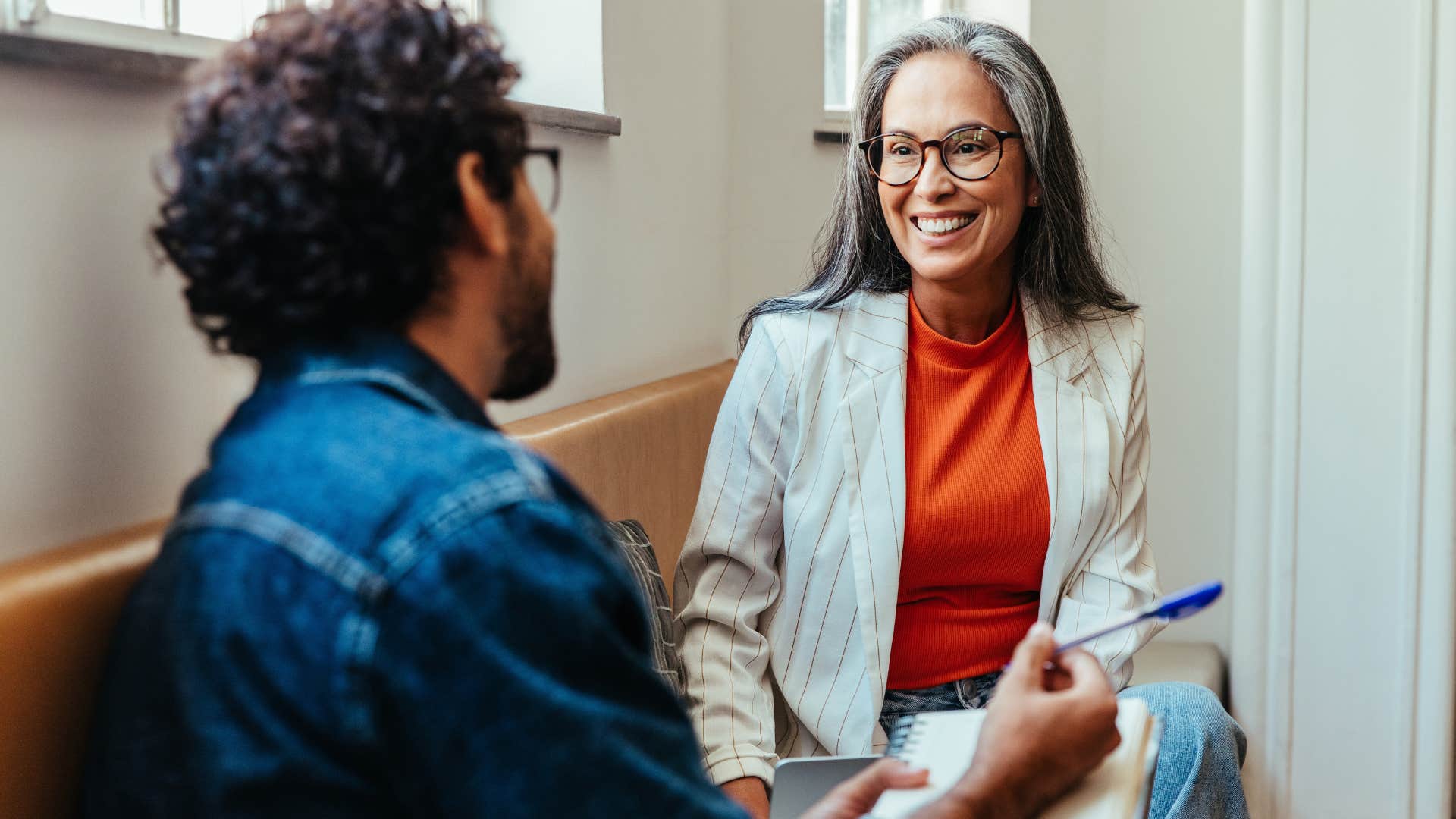 Older woman smiling and talking to a man.