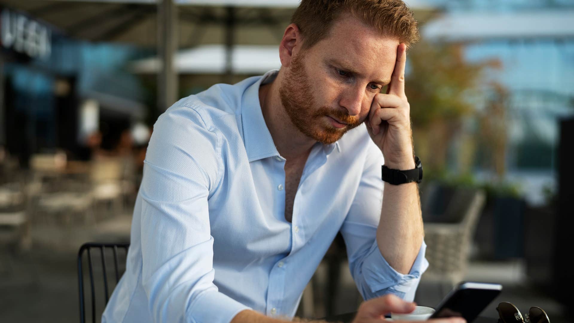 Man looking annoyed at his cell phone. 