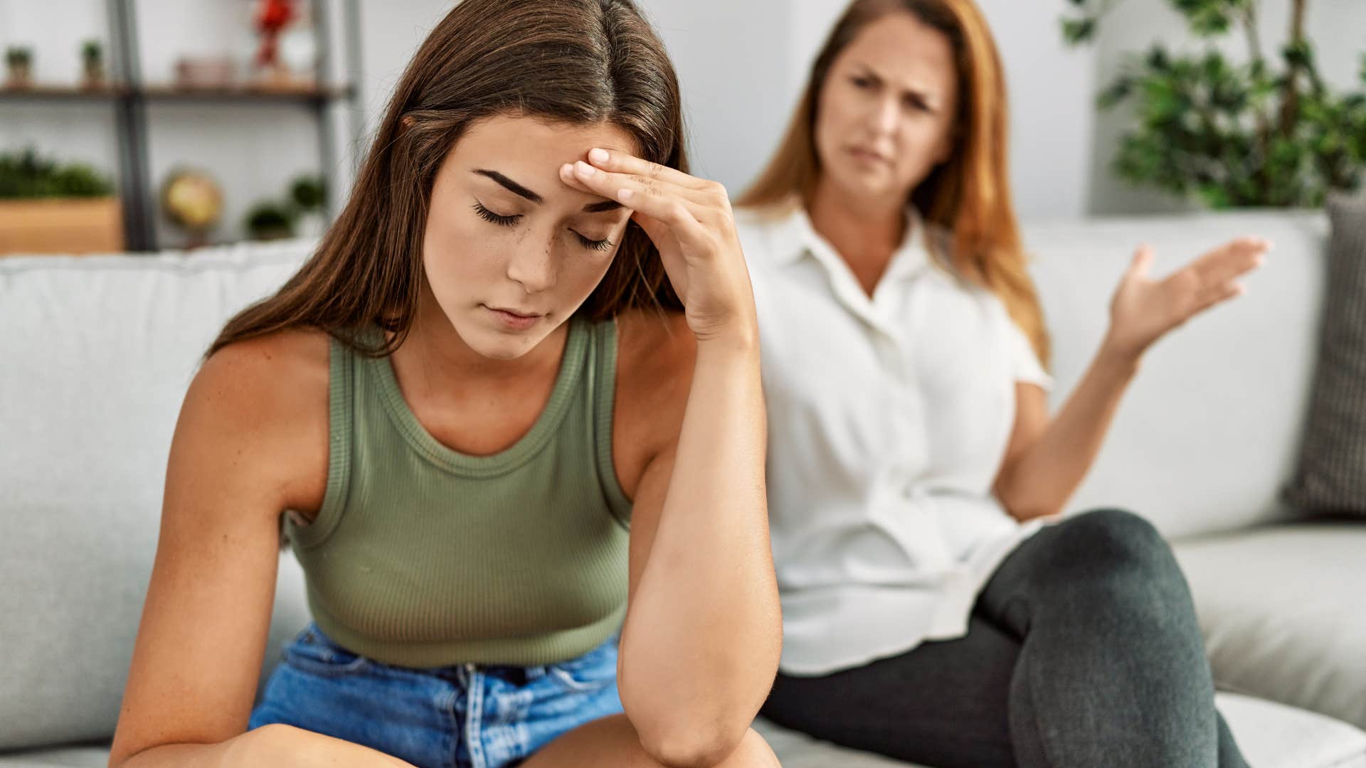 Daughter looking upset while her mother argues with her.