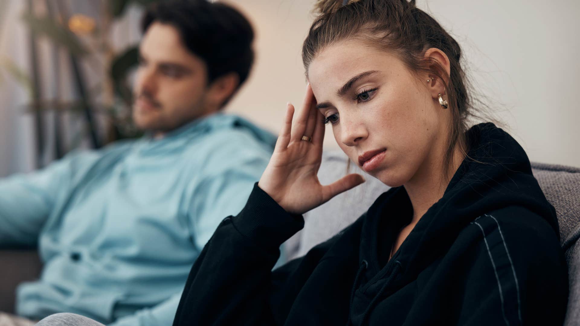 Adult woman looking annoyed turned away from her boyfriend.