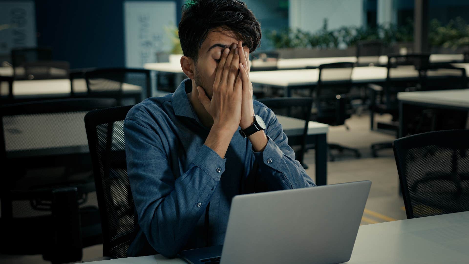 Man looking frustrated at his work desk.