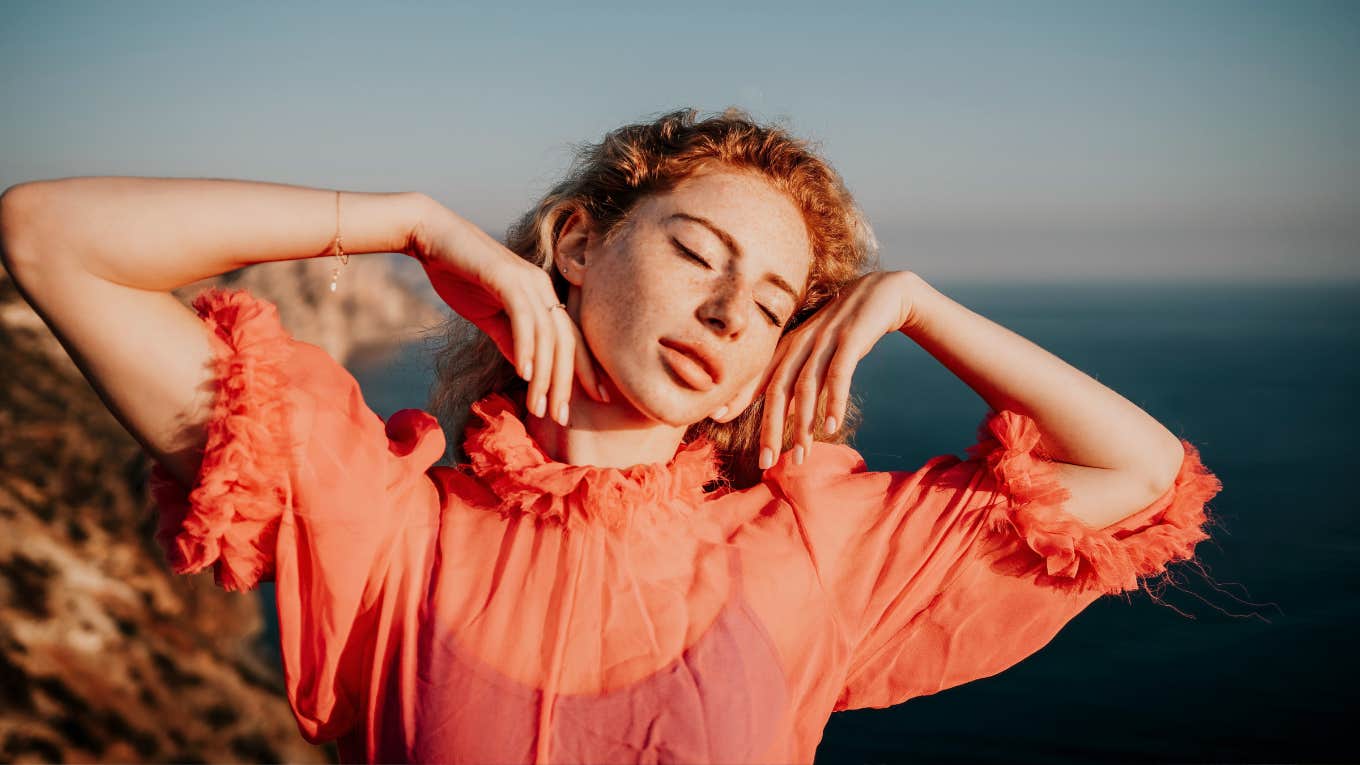 Close up shot of woman with curly red hair and freckles looking off camera