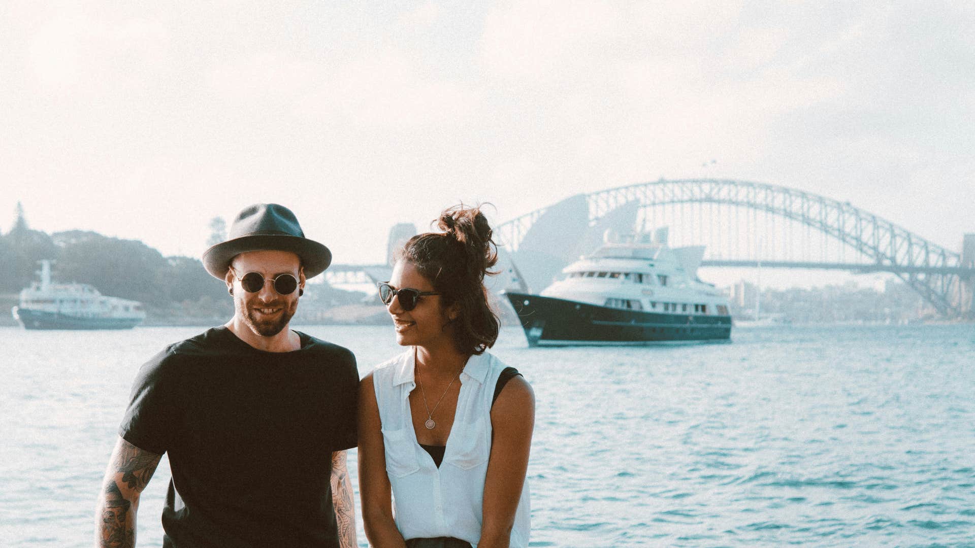 couple smiling next to body of water