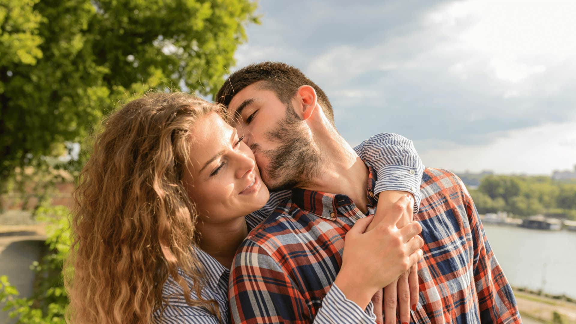 man kissing woman on the cheek