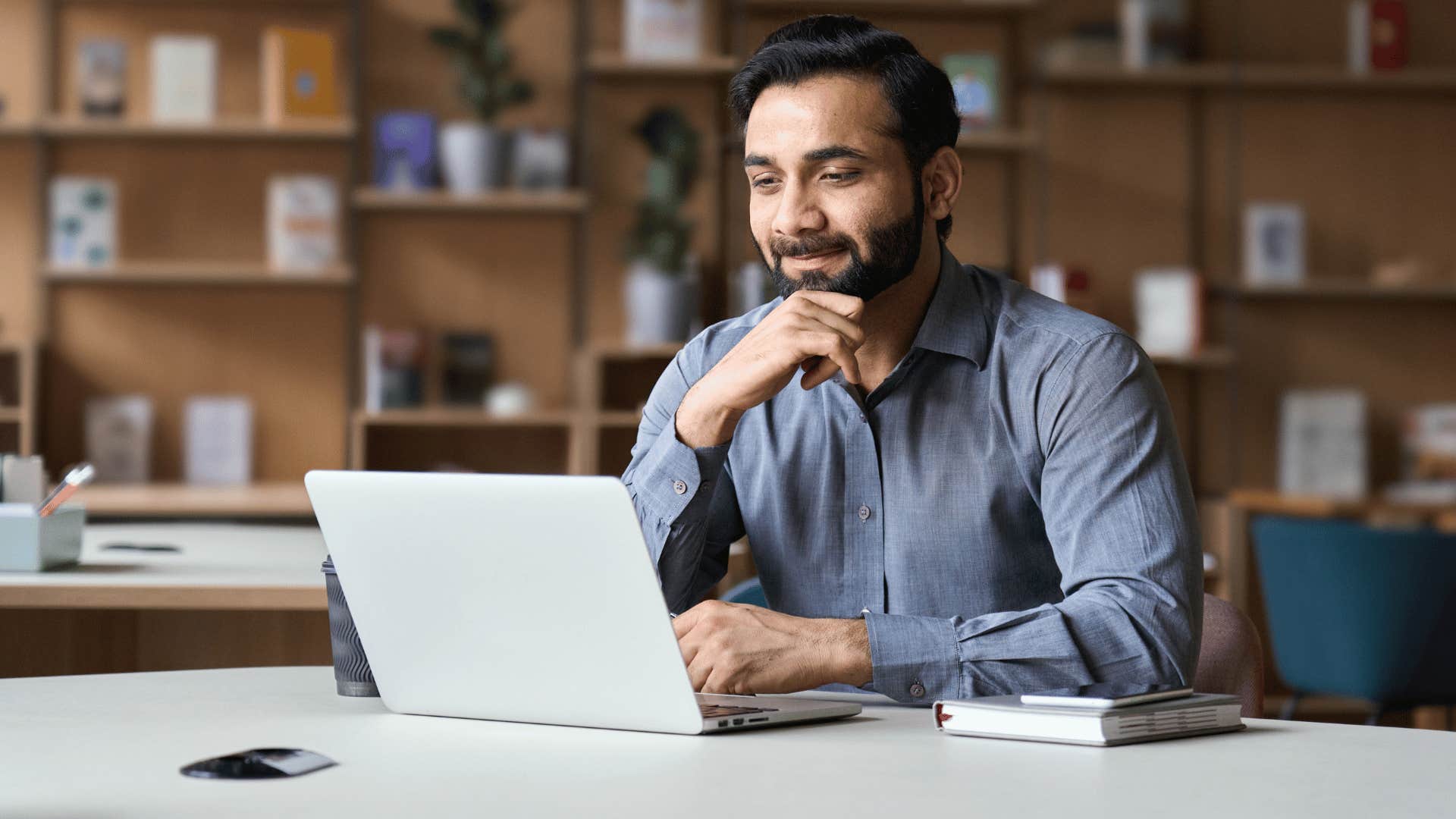 man looking at laptop while thinking