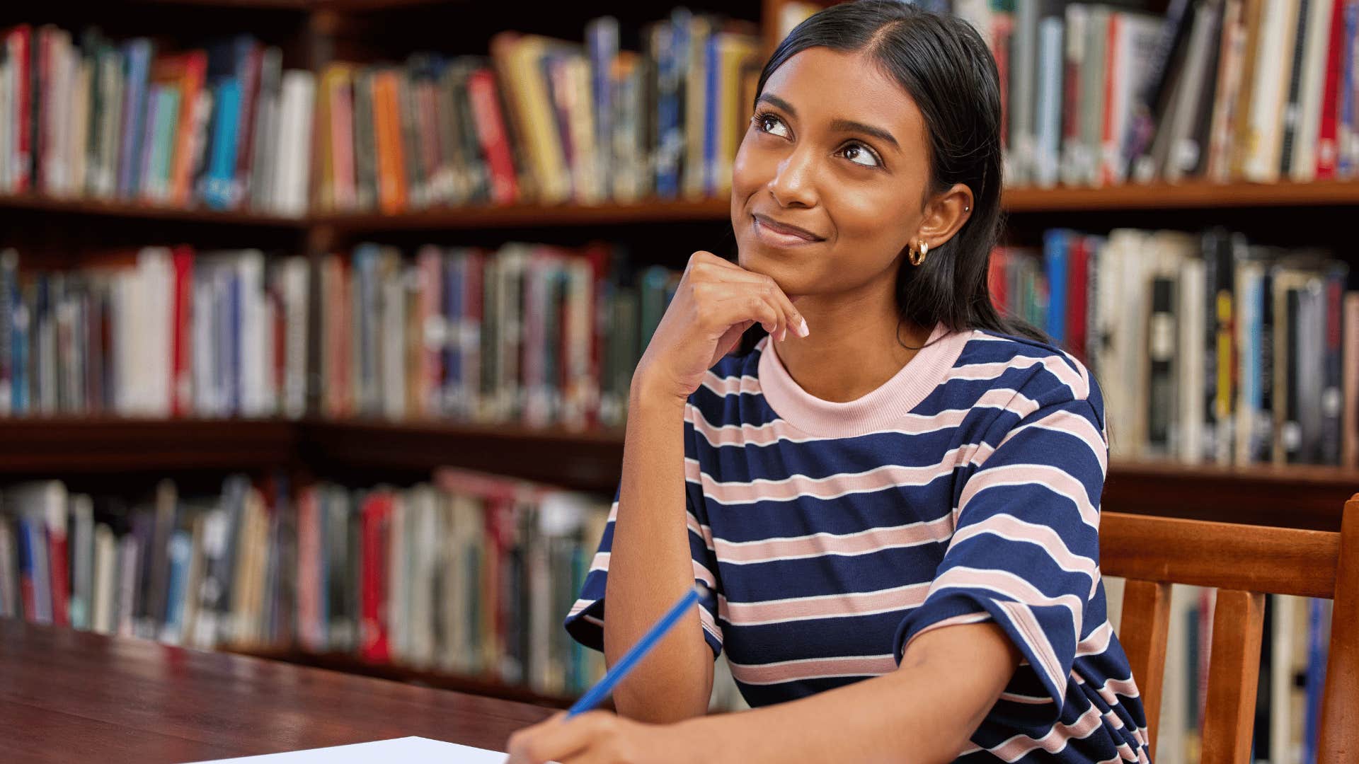 woman thinking while writing