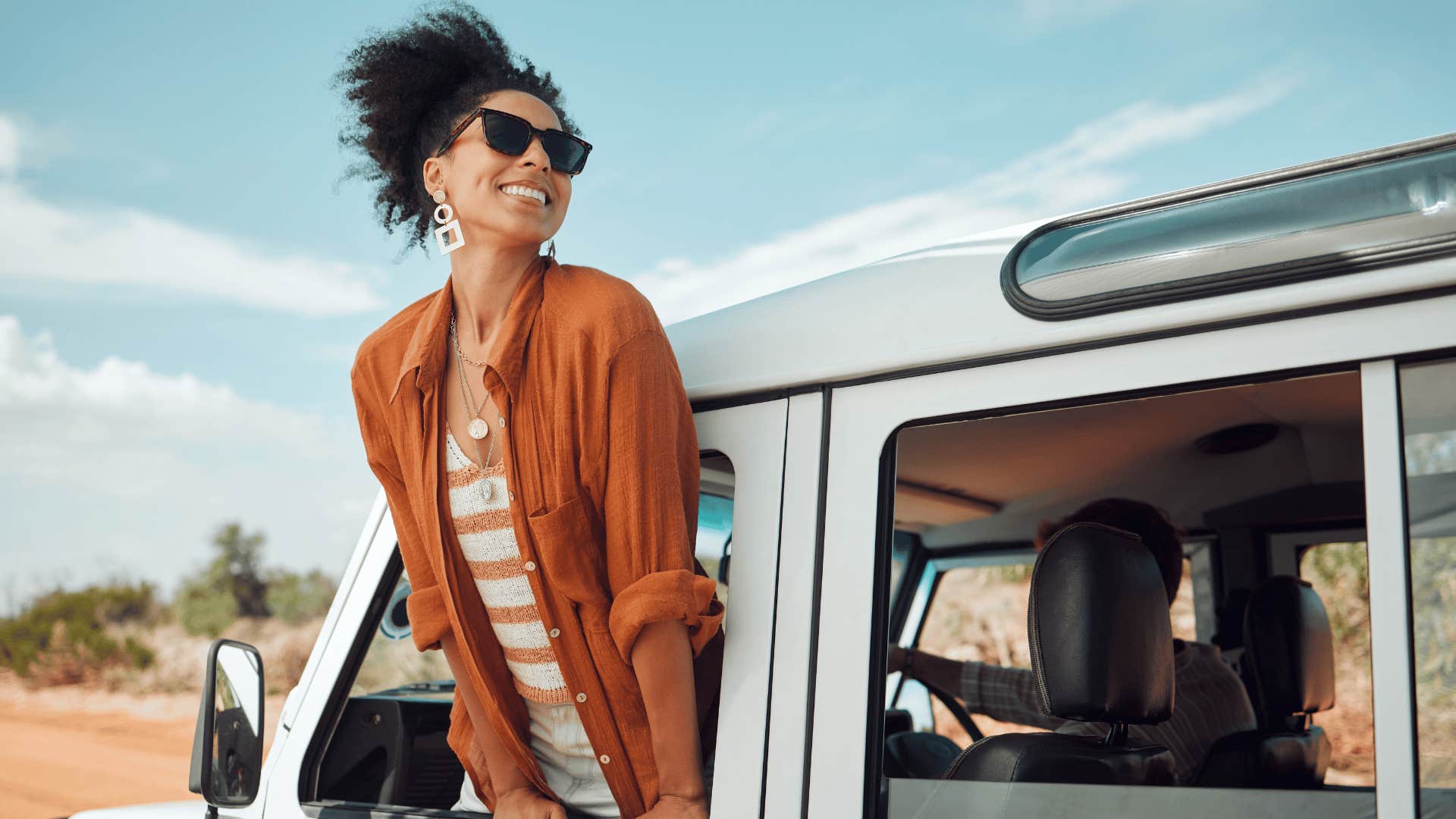 woman smiling while looking out of the car