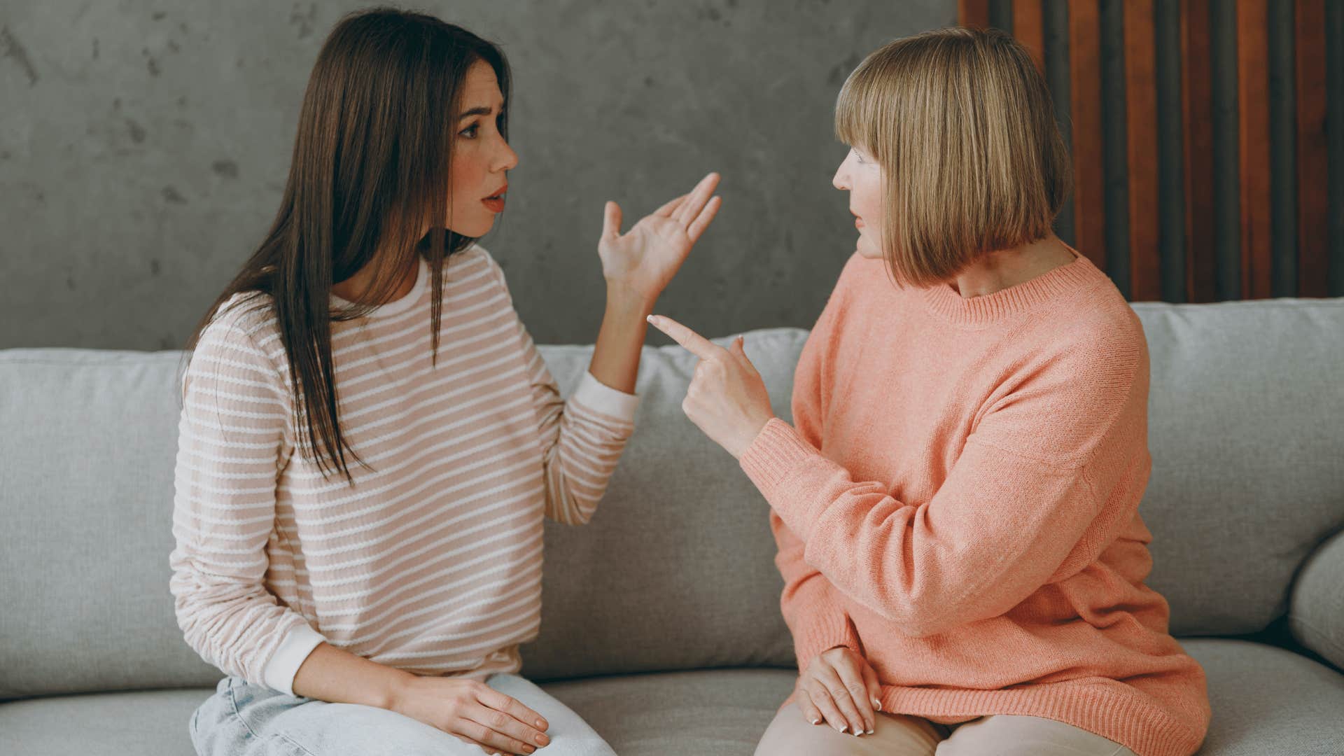 older mother and daughter arguing while sitting on the couch