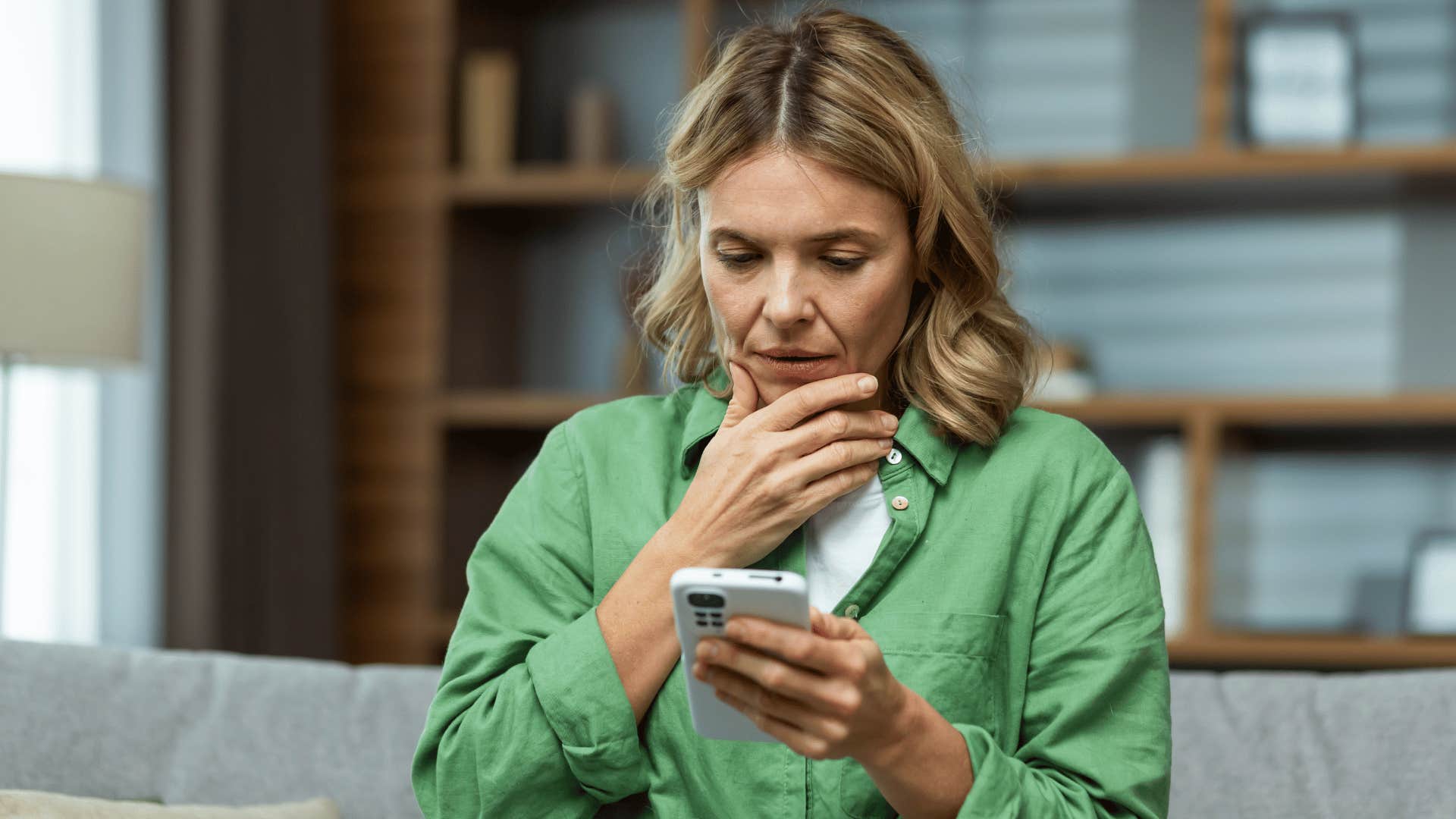 woman looking at her phone upset