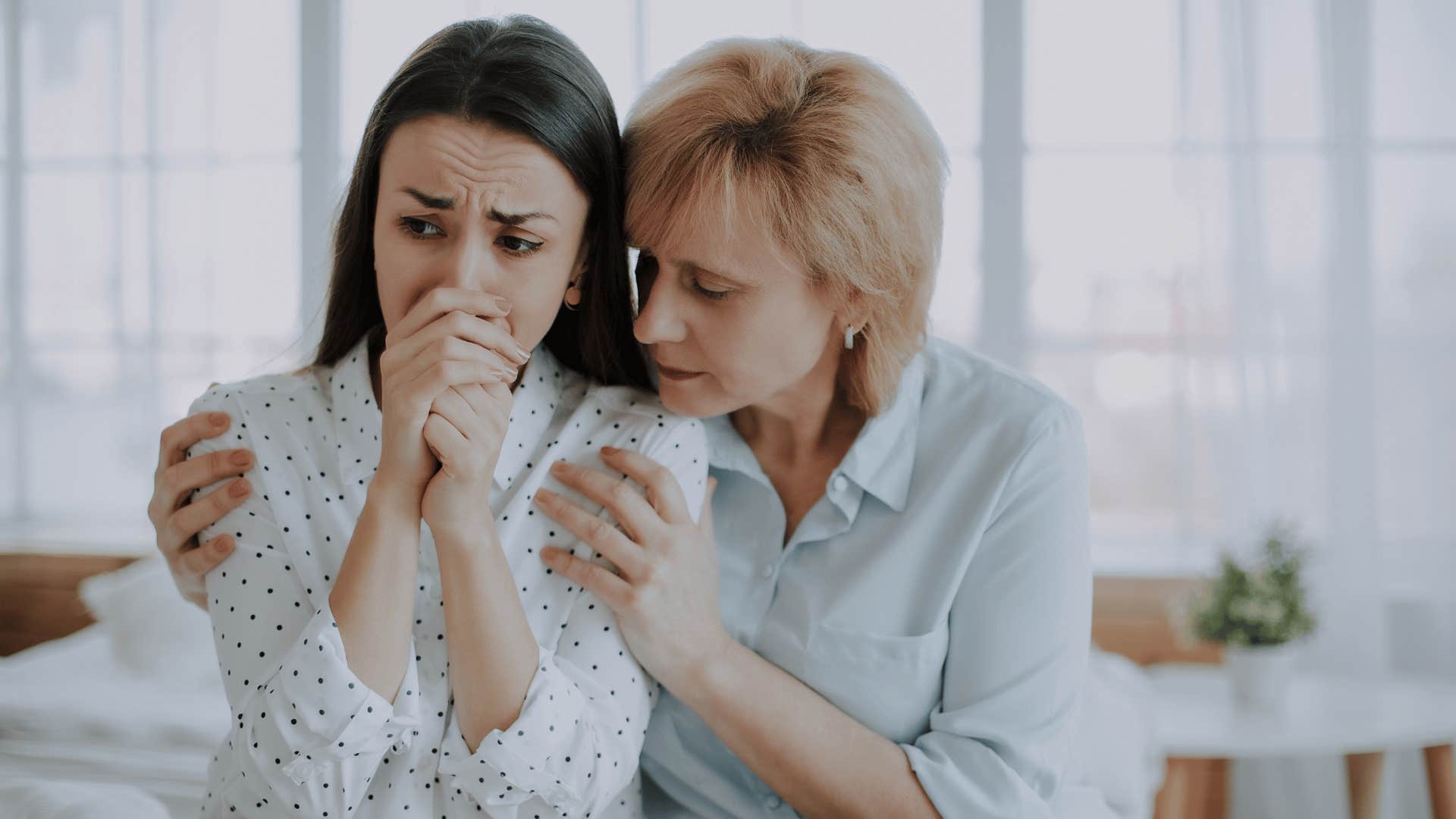 mom comforting older daughter