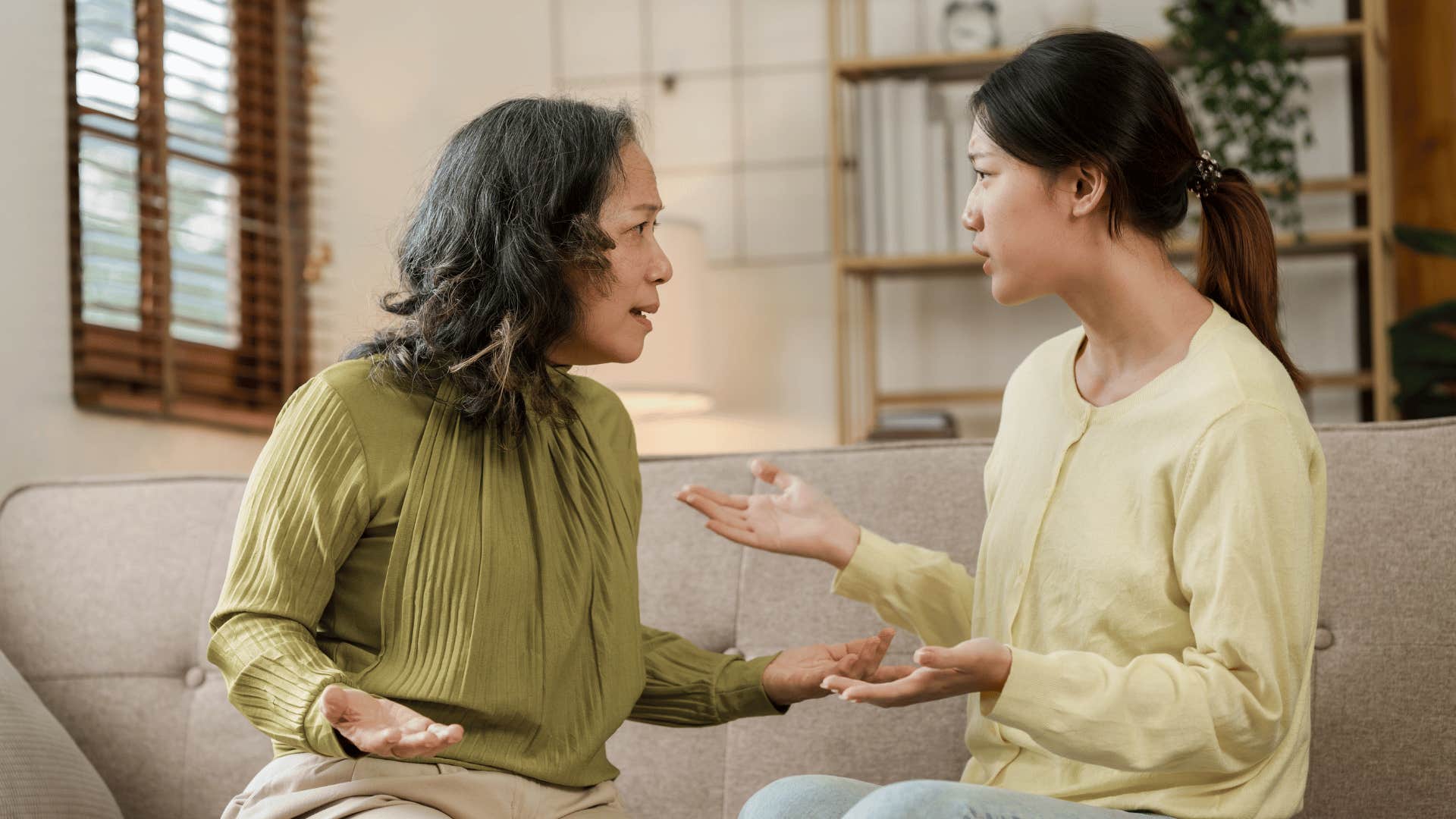 older mother and daughter arguing while sitting on the couch