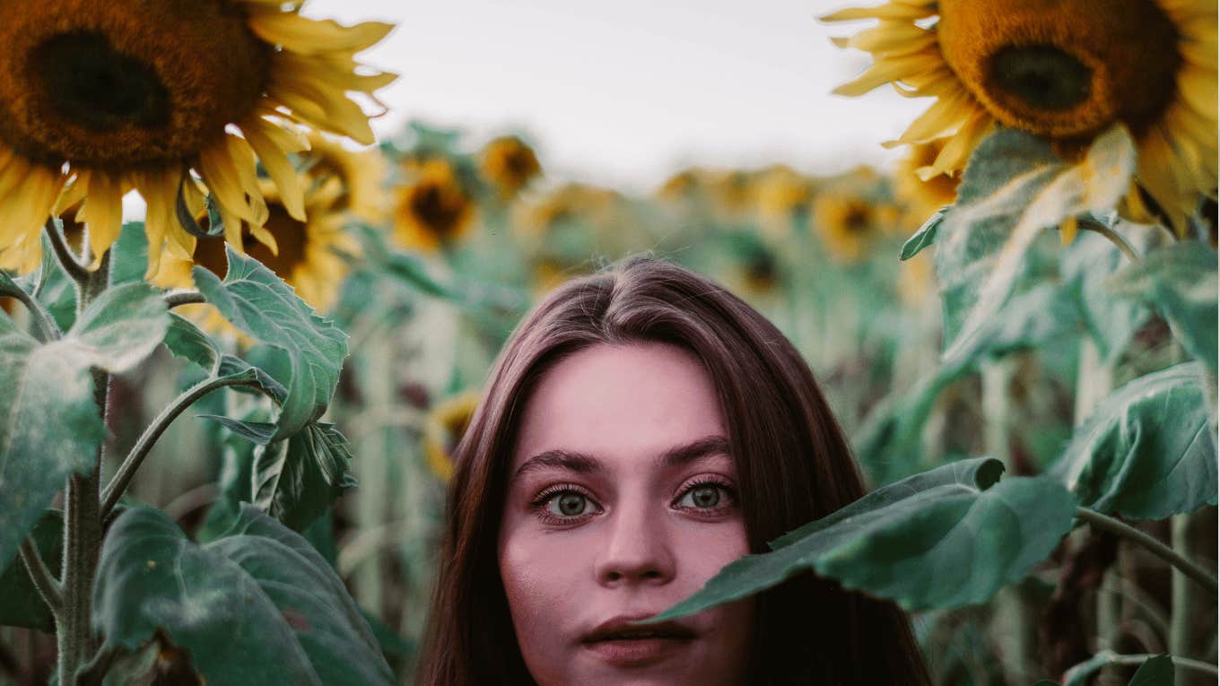 a beautiful woman appearance is hiding in a sunflower field