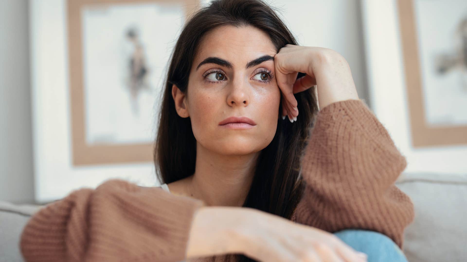 Woman looking sad sitting at home.