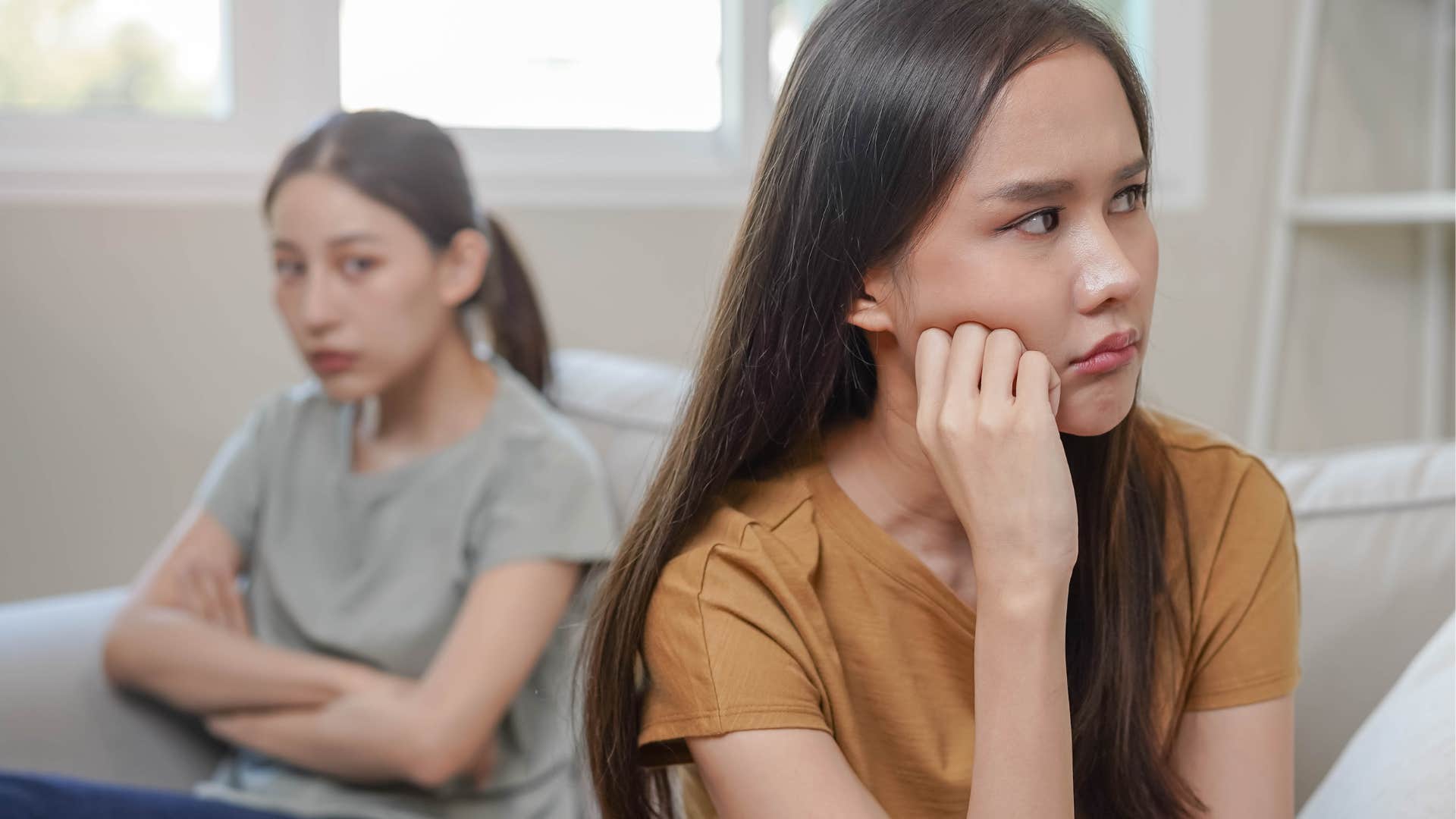 Woman turned away from an upset friend.