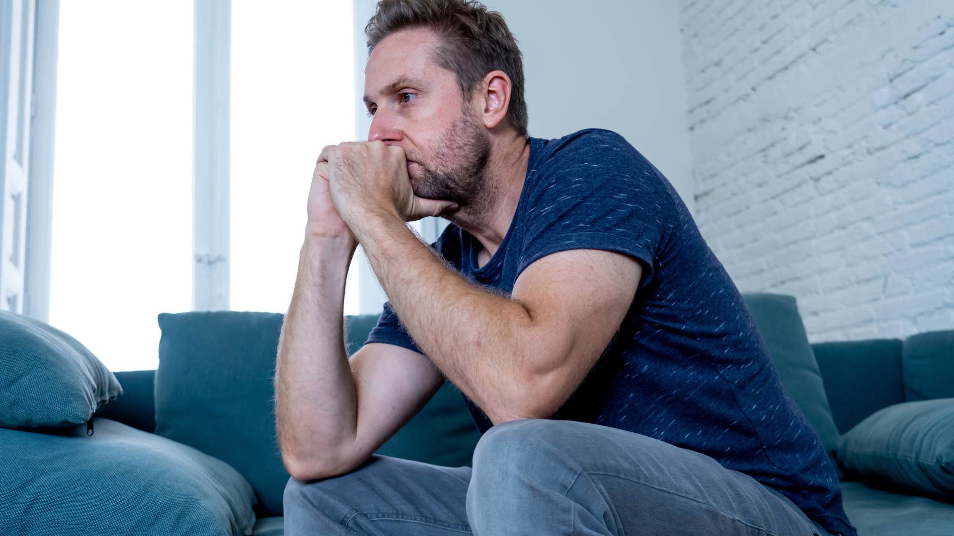 Man looking sad with his head in his hands.