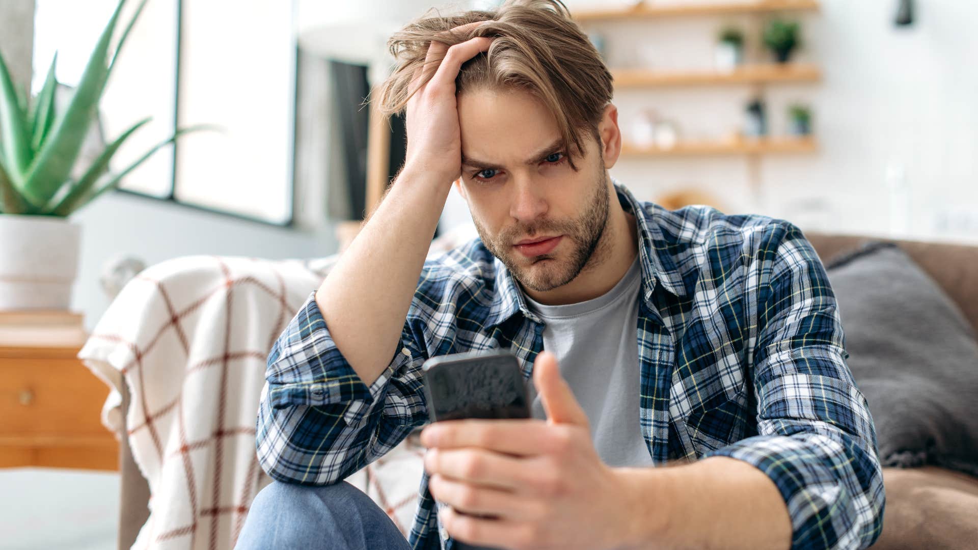 Man looking stressed staring at his phone.