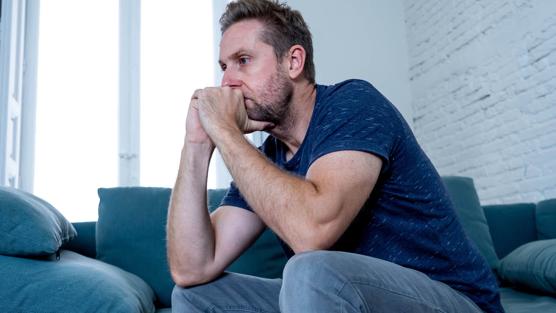 Man looking sad with his head in his hands.