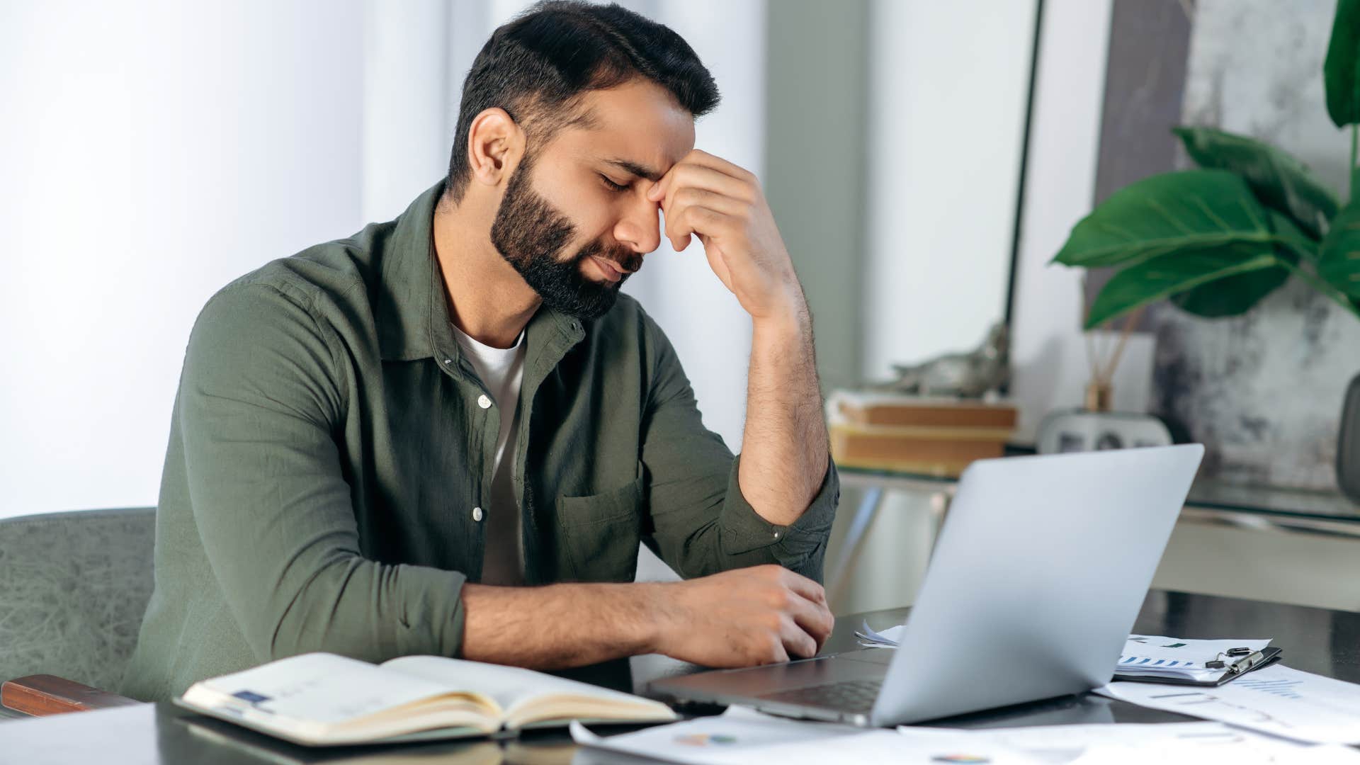 Man looking frustrated staring at his laptop.